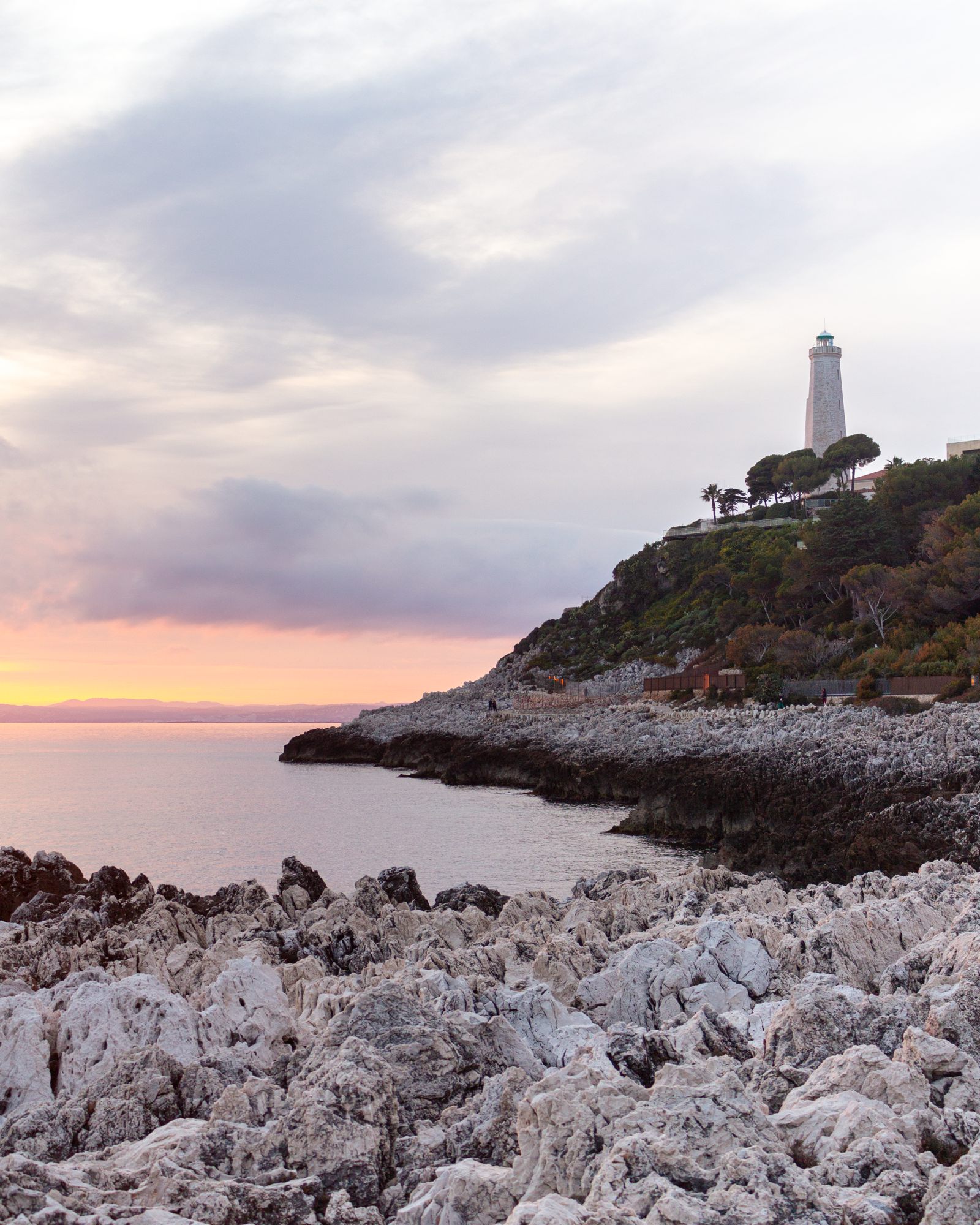 Lighthouse on a rocky point at sunset