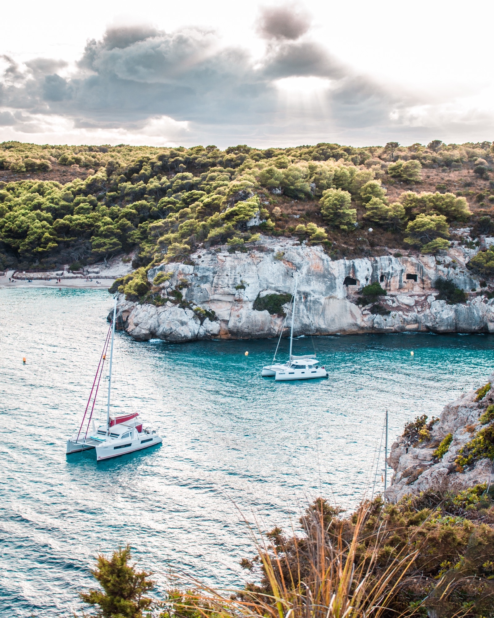 Sailboat below limestone cliffs