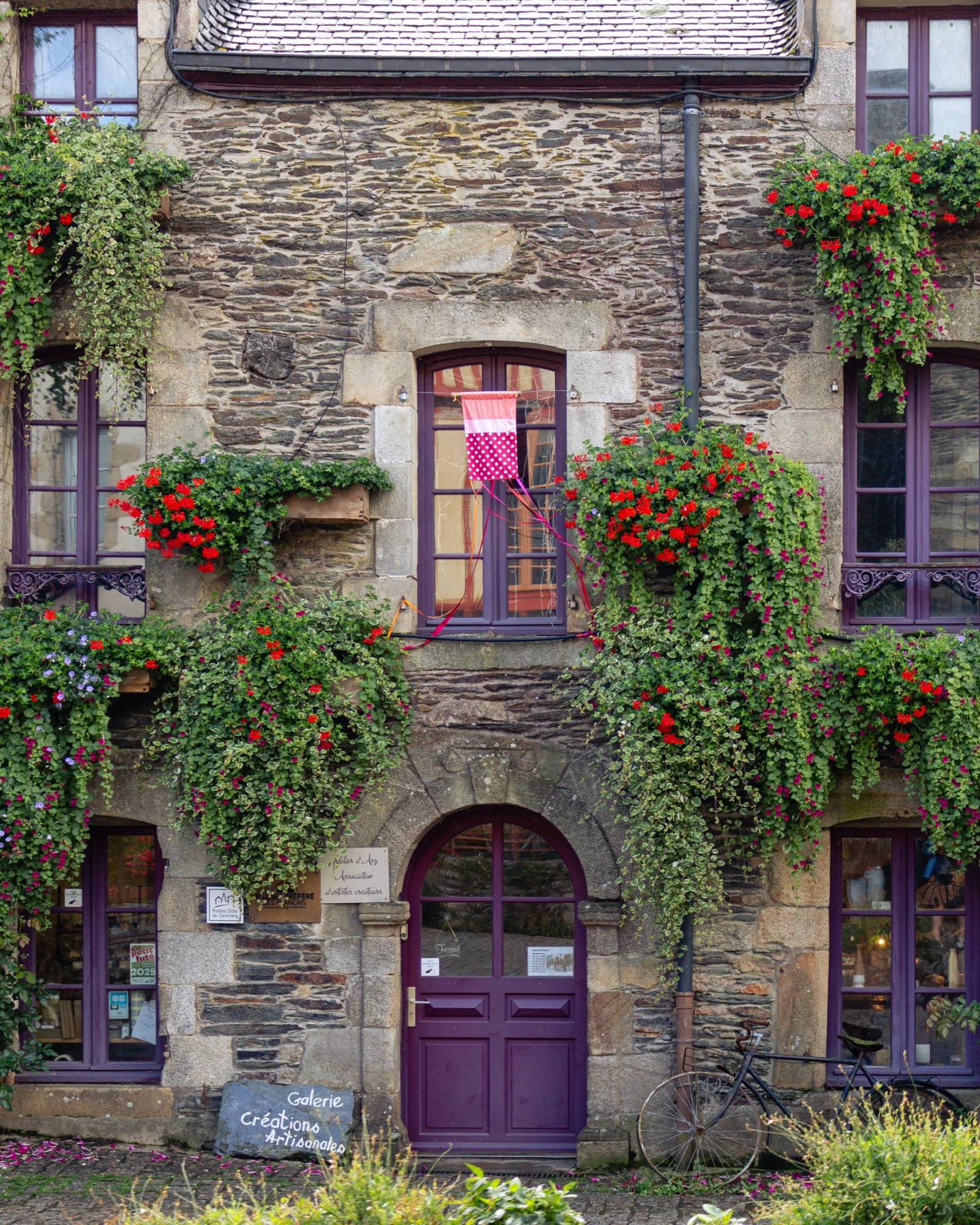 Stone façade with flower boxes and a purple door